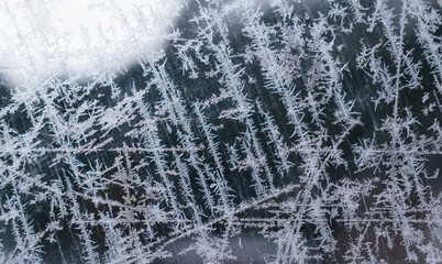 Ice pattern on a glass window. Patterned stripes and curls. Christmas backdrop concept.