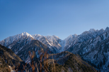 富山県立山町、上市町にある剱岳を見るために雪が積もる冬の中山を登山する風景 A view of climbing a mountain in winter with snow to see Tsurugidake in Tateyama and Kamiichi towns, Toyama Prefecture.
