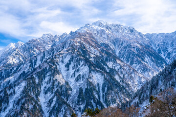 Obraz premium 富山県立山町、上市町にある剱岳を見るために雪が積もる冬の中山を登山する風景 A view of climbing a mountain in winter with snow to see Tsurugidake in Tateyama and Kamiichi towns, Toyama Prefecture.