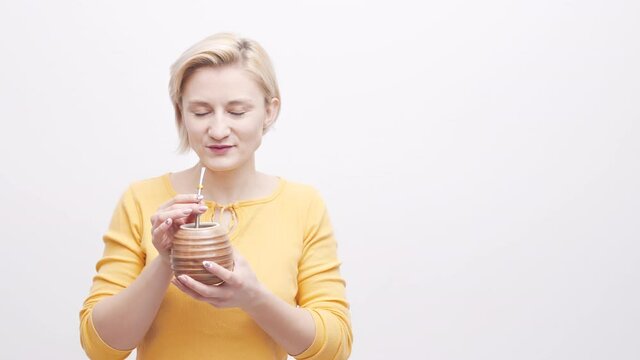 Woman drinking a drink from a beautiful cup with a reusable straw