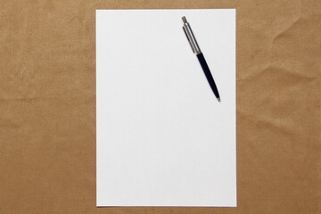 Template of white paper with pen lies on light brown cloth background. Concept of business plan and strategy. Stock photo with empty space for text and design.