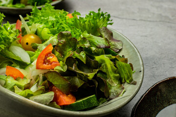 Vegetable salad. The best salad ingredients for weight loss with fresh lettuce, tomatoes and cucumber,olive oil in ceramic bowl. Top view. Copy space. No.11