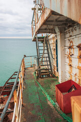 Rusty railing, boards and ladders of the shipwrecked ship. View from the ship.