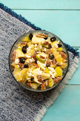 Apple salad with walnuts for Christmas on a turquoise background