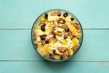 Apple salad with walnuts for Christmas on a turquoise background