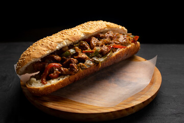 Philly cheese steak with bell pepper on dark background