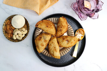 Indian Holi snack popuraly known as Gujia or Gujiya. Also called Karanji in Maharashtra, mostly eaten during Diwali. It is a deep fried sweet dish made from maida and stuffed with khoya or rava. copy.