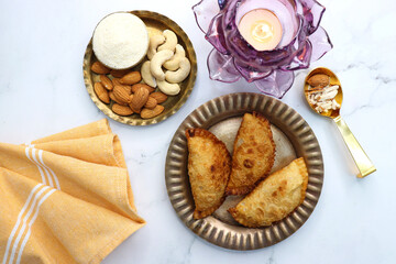 Indian Holi snack popuraly known as Gujia or Gujiya. Also called Karanji in Maharashtra, mostly eaten during Diwali. It is a deep fried sweet dish made from maida and stuffed with khoya or rava. copy.