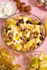 Apple salad with walnuts for Christmas on a pink background