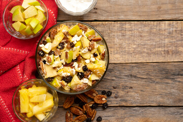 Apple salad with walnuts for Christmas on a wooden background