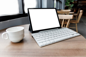 Blank screen laptop computer modern man use room laptop with blank white desktop screen with coffee cup on wooden table in cafe