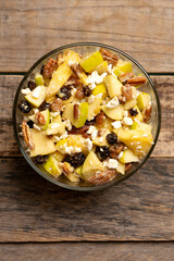 Apple salad with walnuts for Christmas on a wooden background