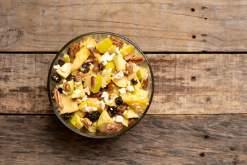Apple salad with walnuts for Christmas on a wooden background