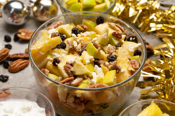 Apple salad with walnuts for Christmas on a gray background