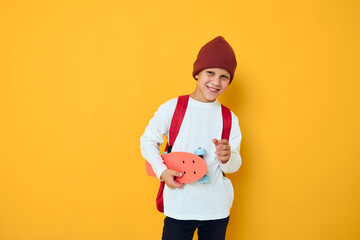Cool smiling boy in a red hat skateboard in his hands Childhood lifestyle concep