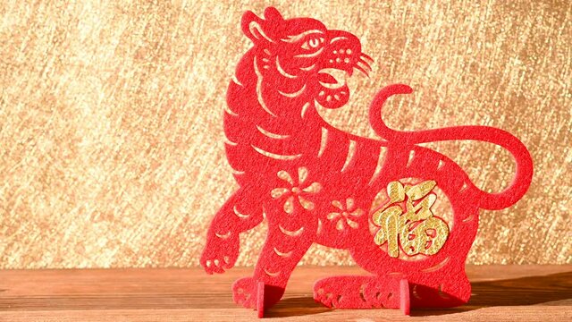 pan view Chinese New Year of tiger 2022 mascot paper cut on a wood table in the morning the Chinese means fortune no logo no trademark