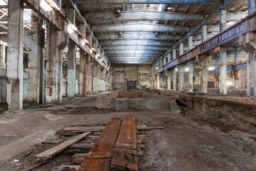 a huge room of an abandoned factory, an empty hangar with iron floors