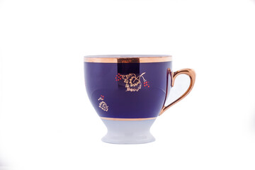 Ceramic blue cup with floral gold ornament isolated on white background
