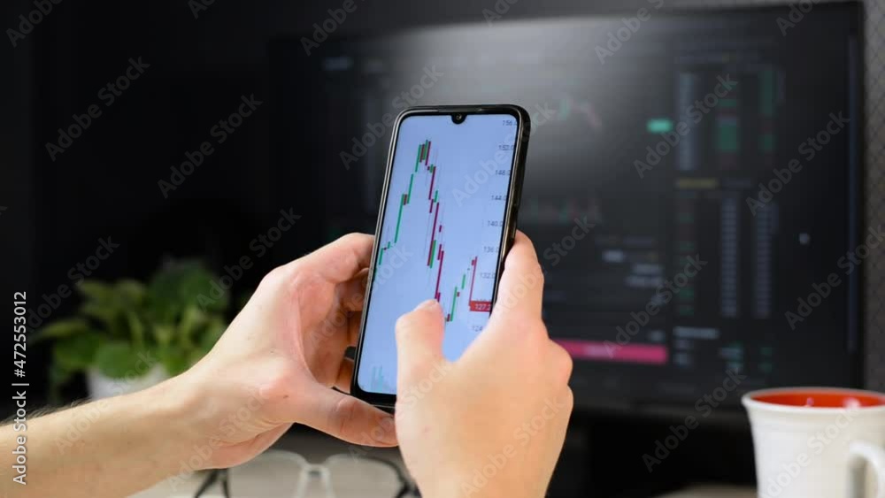 Poster trader investor using mobile application to analyze stock exchange chart while sitting at his workpl