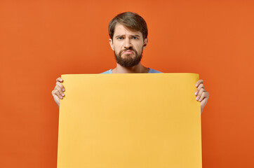 bearded man holding a yellow banner design orange background