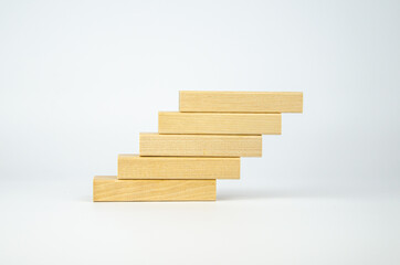 Wooden bars are stacked in the form of steps. Blank blocks of wood on top of each other. The concept of business, interaction, career growth. Template for design, space for text and symbols.