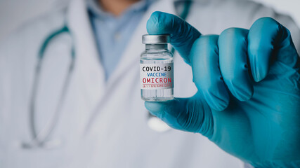 Omicron variant of SARS-CoV-2. New B.1.1.529 Variant of concern. Doctor holds vaccine against new...