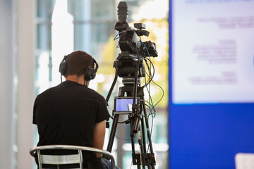 Camcorder Operator filming Live Show sitting on a Chair