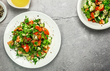 Mediterranean salad with tomatoes, cucumber, coriander, onions, olive oil and lemon in a white ceramic plate. Healthy vegetarian food, oriental and Mediterranean cuisine. Top view. Copy space. No.10