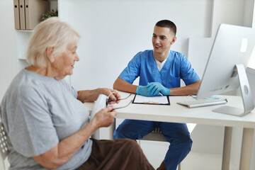 Obraz premium elderly woman patient is examined by a doctor a visit to the hospital