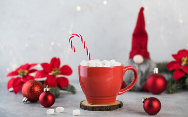  New Year card. Red cocoa mug with marshmallows, striped candy and Christmas tree decorations.