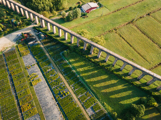 Aerial shot of old aqueduct and vegetables farmland in Italy