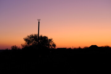 Scenic rural landscape , blue cloudy purple orange sunset sky with pole and nest for stork High quality photo