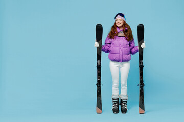 Full body skier happy fun woman in warm purple padded windbreaker jacket goggles mask spend extreme...