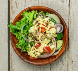 Homemade salad with dressing,cucumber, tomatoes,lettuce,shallot and cream cheese.  Rustic style. Selective Focus. Top view. Copy space. No.05