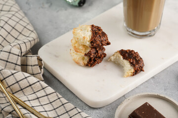 Several coconut flakes cookies dipped in chocolate on a white marble board, christmas decoration
