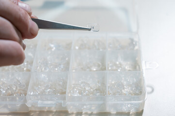 Installation of nose pads in glasses. A male technician repairs broken glasses