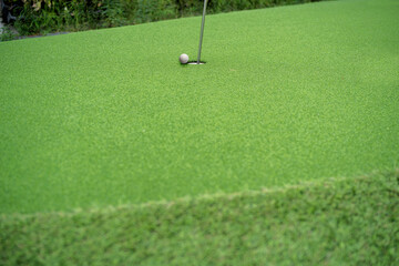 Obraz premium A golf ball on a golf green that is about to go into a hole