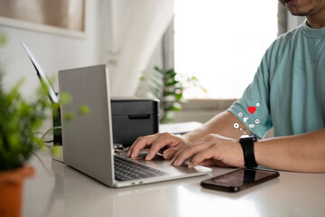 Businessmen sitting at his desk working with his laptop and smart watch alerts