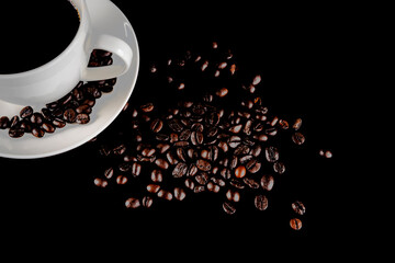 Warm cup of coffee with coffee beans over black background.