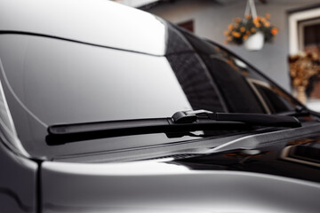Close up of the windshield and wipers of a modern car. Automotive industry. Close up view of a pair...