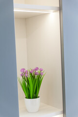 Fresh pink tulip bouquet on a shelf in front of a wooden wall. View with copy space. 