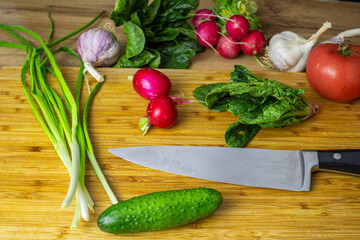 Freshly harvested vegetables. Tomatoes, cucumbers, peppers, parsley, garlic, spinach, green onions on table