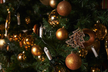 golden balls and garland in the form of candles on the tree