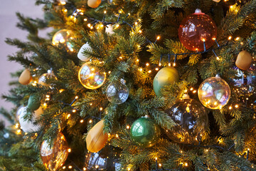 Obraz na płótnie Canvas beautiful christmas tree decorated with transparent glass balls and garland with warm lights