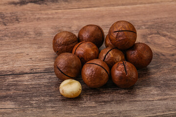 Brown macadamia nut heap over background
