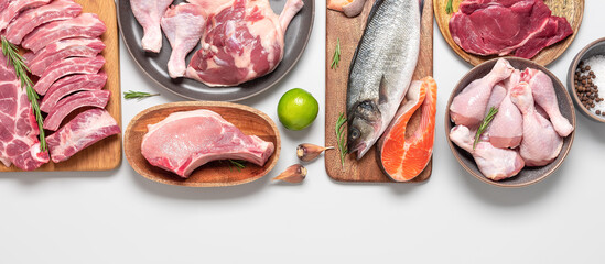 Assortment of raw fresh meat on gray pastel background. Beef, pork, fish, chicken and duck. Top view, flat lay. Wide composition.