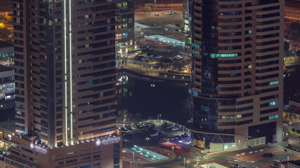 Fototapeta na wymiar Car parking for light vehicles night timelapse in Dubai luxury residential district, aerial view from above.