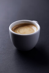 Cup of coffee on dark paper background. Close up.	