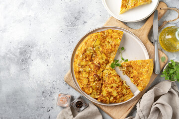Frittata or potato pie in a ceramic plate on a light culinary background. Traditional Italian delicious homemade egg dish on the kitchen table. Top view with a copy space	