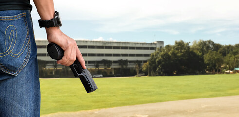 9mm automatic pistol holding in right hand of shooter, concept for security, robbery, gangster, bodyguard around the world. selective focus on pistol. - obrazy, fototapety, plakaty